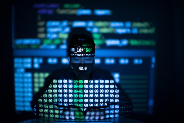 Anonymous hacker in glowing computer interface, scanning for sites that have no security headers to hack.